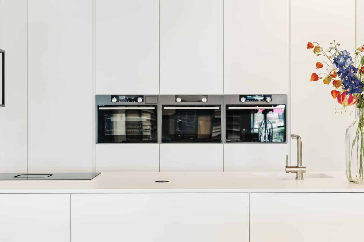 Moderne witte keuken met kookeiland - showroomkeukens
